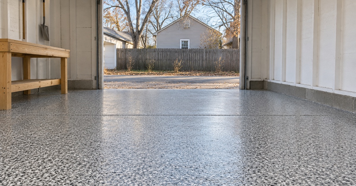 An empty, finished gray and black flake floor in the detached garage behind a Valley Junction house in West Des Moines, the alley door raised.